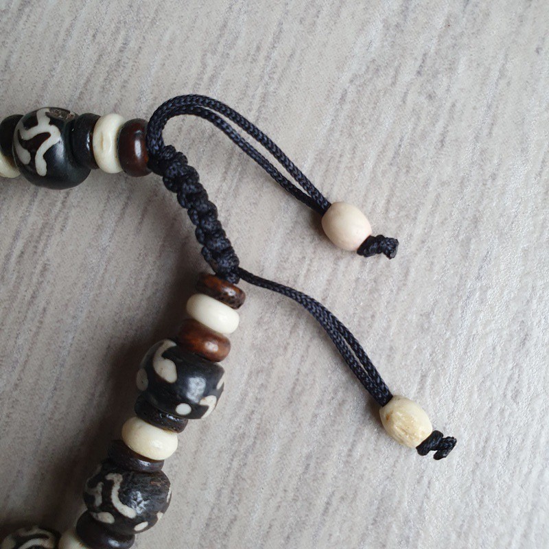 Bracelet en os teinté de motif OM à perles